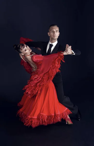 Dans balsal par i röd klänning dans utgör isolerad på svart bakgrund. sensuella professionella dansare dansar vals, tango, slowfox och quickstep — Stockfoto