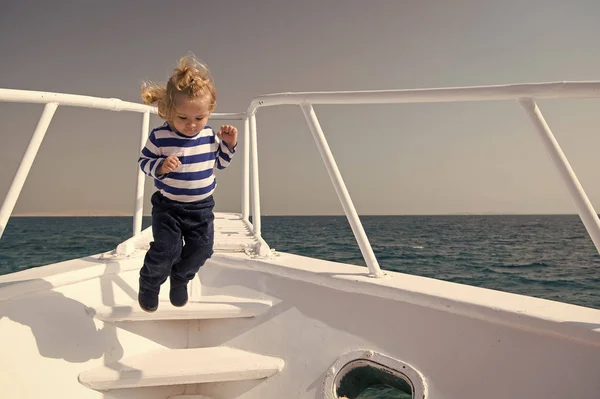 Libertà e gioia. Avventura ragazzo marinaio in viaggio mare. Bambino carino marinaio balzo spensierato prua yacht. Ragazzo adorabile marinaio camicia a righe yacht viaggiare in tutto il mondo. Bambino godere di vacanza sulla nave da crociera — Foto Stock