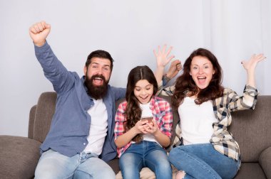 Küçük kız kullanma smartphone ile çocuk anne. Dostu aile birlikte eğleniyor. Anne baba ve meşgul kızı kanepede rahatlatıcı. Aile eğlence. Ebeveyn Danışma belgesi. Aile birlikte hafta sonu geçirmek