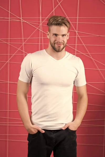 Bärtiger Mann lächelt in weißem T-Shirt und Jeans. Bärtiger Macho mit Bart und Schnurrbart im unrasierten Gesicht — Stockfoto