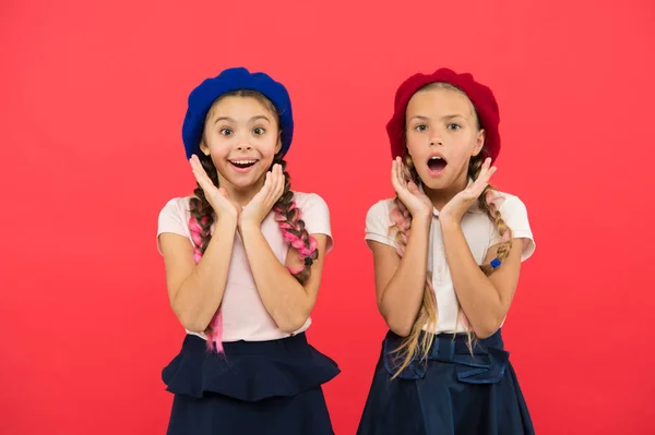 Encantador e chique. Meninas bonitas com o mesmo penteado. Crianças pequenas com tranças de cabelo comprido. Meninas da moda com cabelo amarrado em tranças. Crianças pequenas vestindo boinas francesas elegantes. meninas estilo francês — Fotografia de Stock