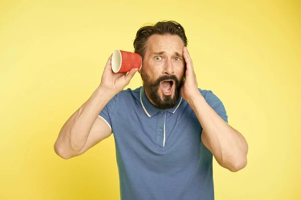 Shocking rumors. Man bearded mature guy eavesdrops with cup yellow background. Find out new scandalous rumors first. Guy shocked eavesdrops scandalous rumors. Curiosity and impoliteness — Stock Photo, Image