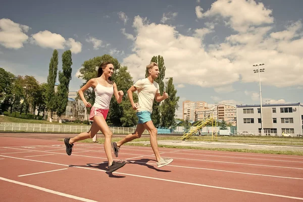 Couple running on arena track. — Stock Photo, Image