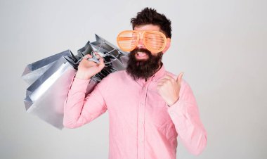 Nasıl sonraki tatil için hazır olun. Adam çok alışveriş torbaları ile sakallı hippi. Üstünde siyah Cuma alışveriş. Mutlu grup kağıt torbalar ile alışveriş. Karlı bir anlaşma. Alışveriş bağımlısı tüketici