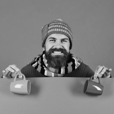 Sakallı ve gülen yüzlü hippi çay ya da kahve içer.