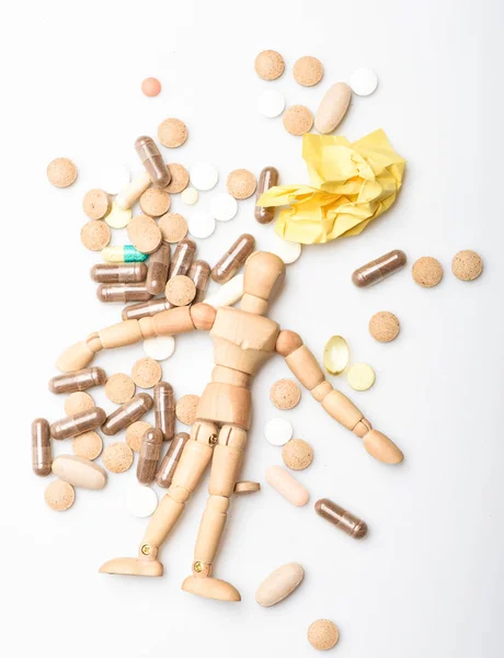 Atención médica y problemas. Inmunidad y vitaminas medicinales. Sobredosis y muerte. Receta médica. Maniquí humano de madera yacía en un montón de pastillas y tabletas. Toma el concepto de medicina. Salud y tratamiento —  Fotos de Stock