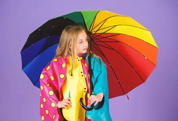 Wasserfestes Zubehör für Kinder. Wasserdichte Accessoires machen Regentage fröhlich und angenehm. Mädchen glücklich halten bunten Regenschirm tragen wasserdichten Mantel. Regenwetter mit richtiger Kleidung genießen — Stockfoto