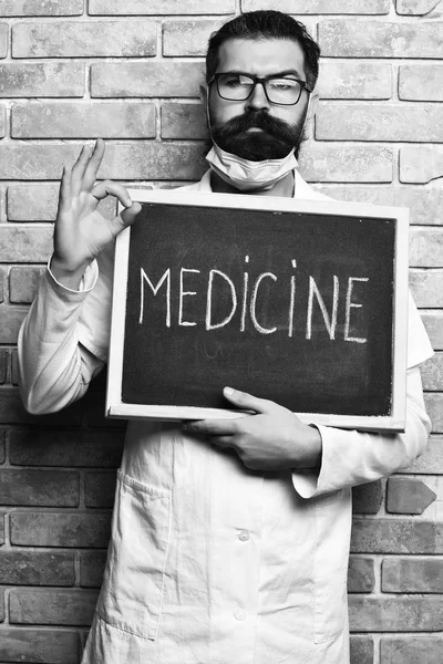 Barbu brutal caucasien médecin holding conseil avec médecine inscription — Photo