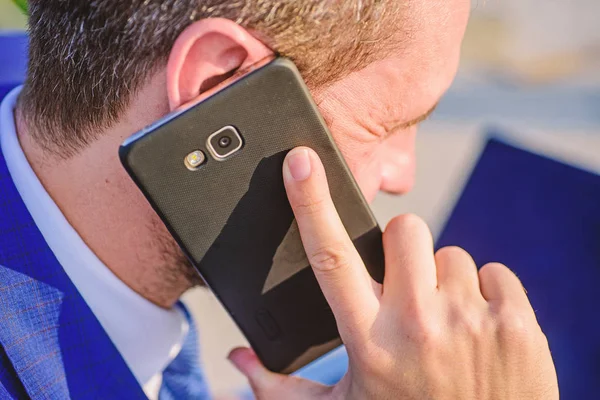 Businessman holds smartphone near ear close up. Consultation and help concept. How can I help you. Man formal suit call support while works with laptop rear view. Call technical support service — Stock Photo, Image