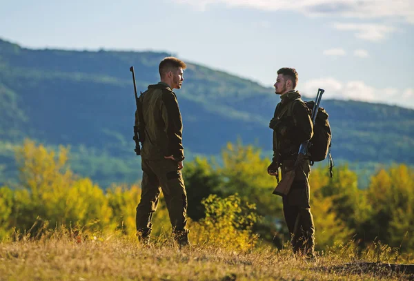 Păstrătorii de gamekeepers mers pe fundal munți. Conceptul de ocupație Gamekeeper. Gamekeepers însorit toamna zi. Vânătoarea cu partenerul oferă o mai mare distracție și satisfacție de siguranță. Gamekeeper puști natura mediu — Fotografie, imagine de stoc