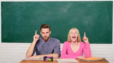 Adam ve kız sınıfta masada otur. Doğru cevap onların aklında. Kolej veya üniversite okuyor. Ücretsiz program uygulanır. Kaç arkadaş üniversite okuyan öğrenciler. Üniversite hayatının tadını çıkarıyor