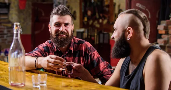 Men relaxing at bar. Strong alcohol drinks. Friday relaxation in bar. Friends relaxing in bar pub. Cheers concept. Lets get drunk. Hipster brutal bearded man spend leisure with friend at bar counter