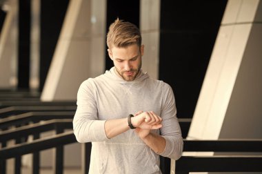 Adam atlet sıkı yüz fitness izci, kentsel arka plan kontrol. Atlet ile kıl fitness izci veya adım sayar. Sporcu pedometre gadget ile eğitim. Spor araç konsepti