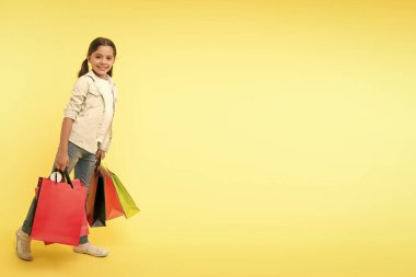 Alışveriş günü. Mutlu çocukla alışveriş günü. Alışveriş gününde gülümseyen küçük kız. Alışveriş gününden sonra paketli kız, boşluğu kopyala.