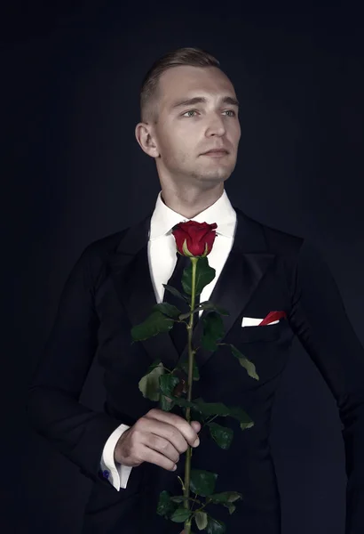 Man in suit with rose on dark background — Stock Photo, Image