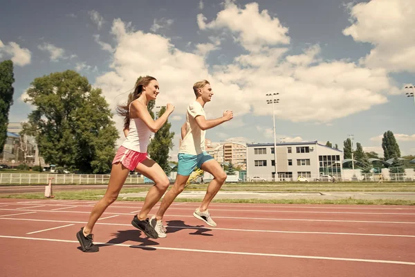 Couple running on arena track. — Stock Photo, Image