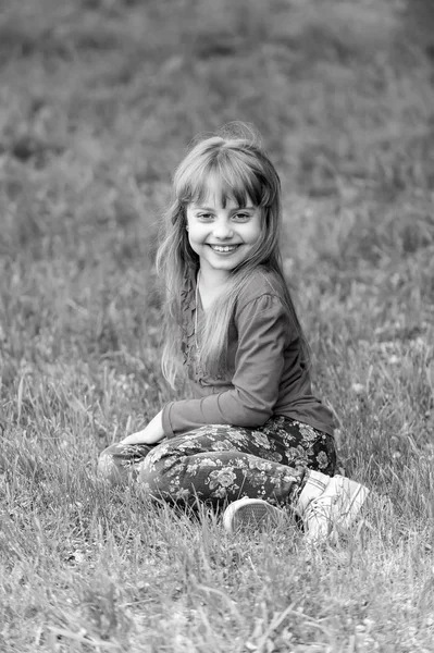 Kid smile on green grass, spring. black and white — Stock Photo, Image