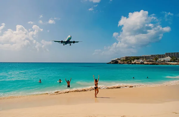 Avión de tierra sobre la gente en la playa de Phillipsburg, San Martín. Vuelo en jet sobre el mar azul. Avión en cielo azul nublado. Vacaciones en la playa del Caribe. Wanderlust, viaje y viaje — Foto de Stock