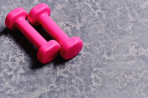 運動とスポーツのコンセプトです。明るいピンクのプラスチック製のダンベル — ストック写真