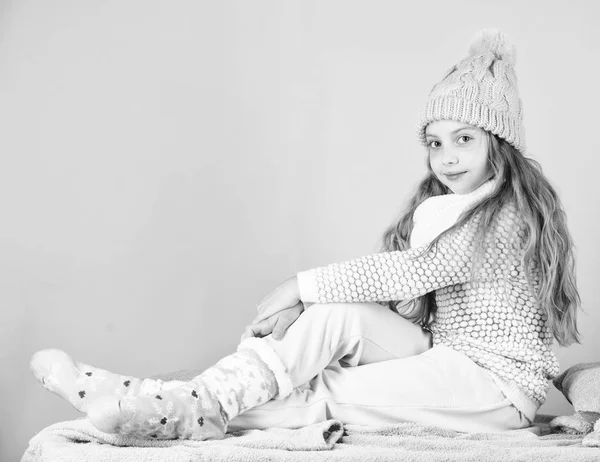 Kid flicka bära söt stickad fashionabla mössa och bekväma mysiga kläder. Flicka långt hår avkopplande rosa bakgrund. Vinter mode för barn. Kid leende modell. Winter fashion-konceptet — Stockfoto