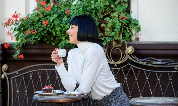 Meisje ontspannen café met koffie en dessert. De aantrekkelijke elegante brunette vrouw geniet van gastronomische koffie café terras achtergrond. Gastronomisch concept. Aangename tijd en ontspanning. Delicious en gastronomische drinken — Stockfoto