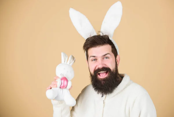 Celebração de férias de primavera. Hipster com longas orelhas de coelho segurando a lebre poedeira. Homem barbudo com brinquedo de coelho e ovo de Páscoa. Coelho da Páscoa entregando ovos coloridos. Primavera e coelho — Fotografia de Stock