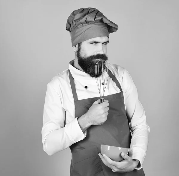 Yemek pişirme süreci konsepti. Bordo üniformalı baştan çıkarıcı yüzlü aşçı. — Stok fotoğraf