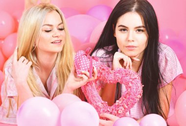 Sevgililer günü kavramı. Kızlar balonlar yatıyordu, kalp oyuncaklar, pembe arka plan almıştır. Kız kardeşim, arkadaşlarım pijama pijama partisinde. Sarışın ve esmer gülümseyen yüzler aşk ve Tarih hakkında rüya üzerinde