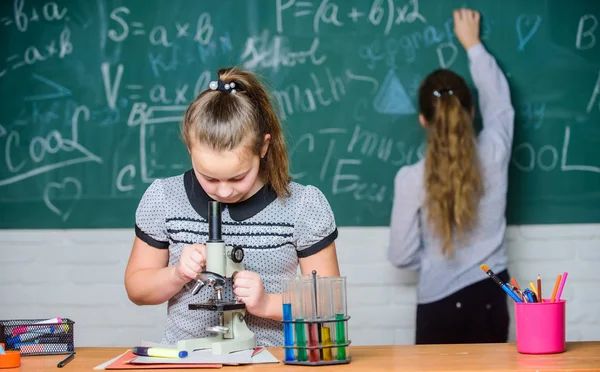 Chemistry classes. Educational experiment. Girls classmates study chemistry. Microscope test tubes chemical reactions. Pupils at chalkboard chemistry lesson. Laboratory practice. Fascinating science — Stock Photo, Image