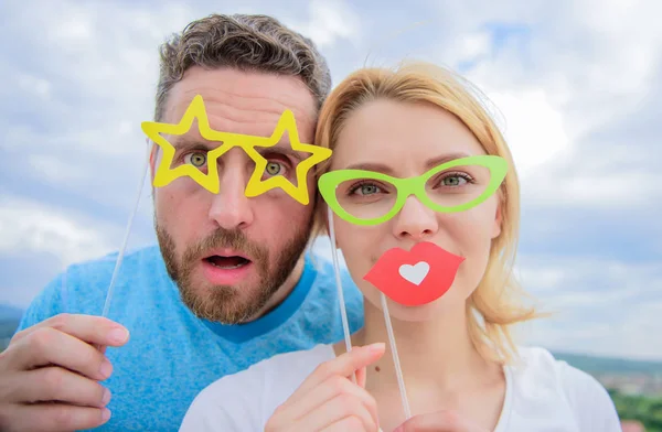 Funky stil. Sexig tjej och stilig man bära falska glasögon tillbehör. Foto monter party fest. Rolig par i part photobooth rekvisita. Par i kärlek njuta av part tid på mulen himmel — Stockfoto