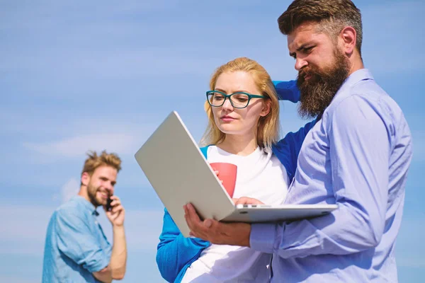 Fresh air helps to refresh mind. Colleagues laptop work outdoor sunny day, sky background. Friends enjoy fresh air and keep working. Outdoor workspace concept. Colleagues with laptop discussing plan