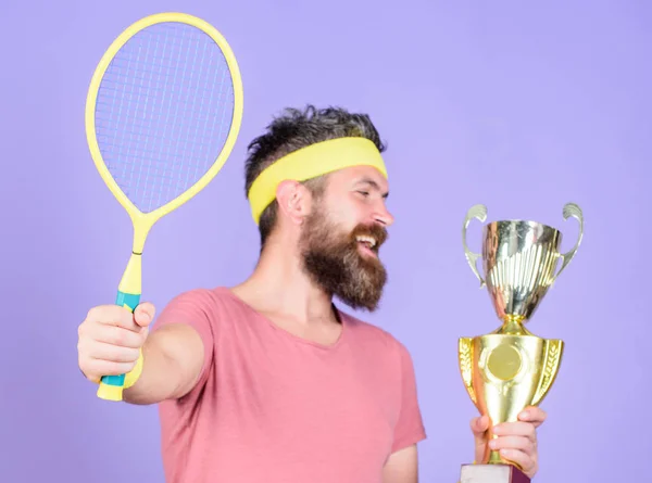 Athlete hold tennis racket and golden goblet. Win tennis game. Man bearded hipster wear sport outfit. Success and achievement. Win every tennis match i take part in. Tennis player win championship