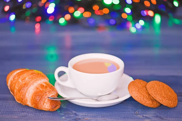 Coffee time christmas eve. Fresh brewed coffee in white cup or mug on defocused garland lights background. Coffee drink winter holiday new year. Enjoying coffee on christmas morning