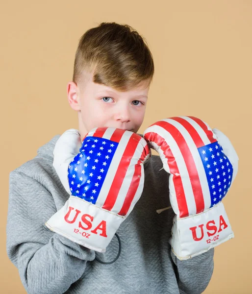 Start boxing career. Boy sportsman wear boxing gloves with usa flag. American boxer concept. Child sporty athlete practicing boxing skills. Boxing sport. Towards victory. Confident in his strength