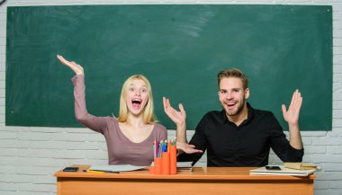 Bu inanılmaz. Üniversite öğrencilerinin el hareketi. Lise eğitimi. Sınıfta okuyan bir çift. Erkek ve kadın okula geri. Güzel öğretmen ve yakışıklı öğretmen masa başında gülümseyen mutlu