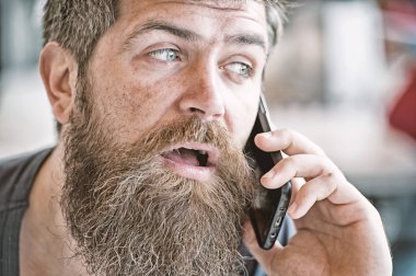 Sakal ve bıyık cep telefonu defocused konuşma geçmişi olan adam. Sakallı adam tutun cep telefonu. Sakallı hippi smartphone telefon iletişim. Mobil iletişim. İletişim kavramı