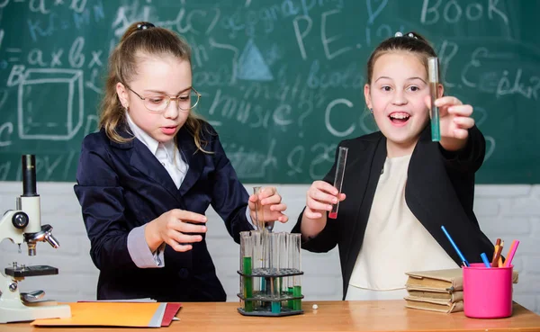Óvatosan végezzen kémiai reakciót. Alapismeretek a kémiáról. A lányok kémiát tanulnak. Tedd érdekessé a kémiát. Oktatási kísérlet koncepció. Mikroszkóp és kémcsövek az asztalon — Stock Fotó