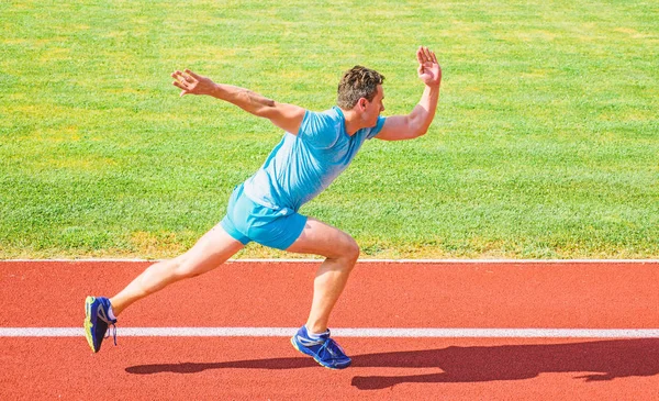 Aumentar o conceito de velocidade. Homem atleta corredor empurrar fora posição inicial estádio caminho dia ensolarado. Como começar a correr. Corrida de sprint de corredor no estádio. Corredor capturado em movimento logo após o início da corrida — Fotografia de Stock