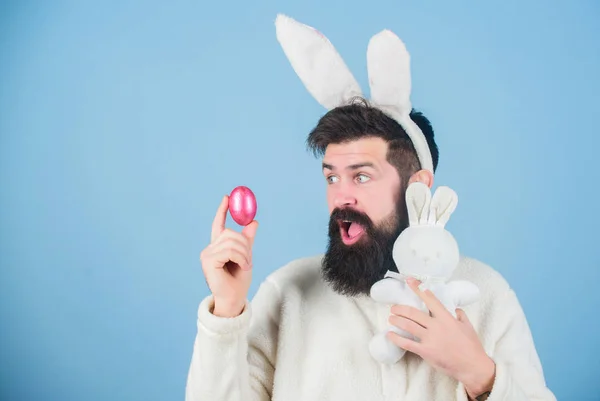 Що в ньому для мене. Пасхальний кролик доставляє кольорові яйця. Бородатий чоловік з іграшкою кролика та пасхальним яйцем. Гіпстер з довгими вухами кролика, що тримають заєць для відкладання яєць. Святкування весняних свят — стокове фото