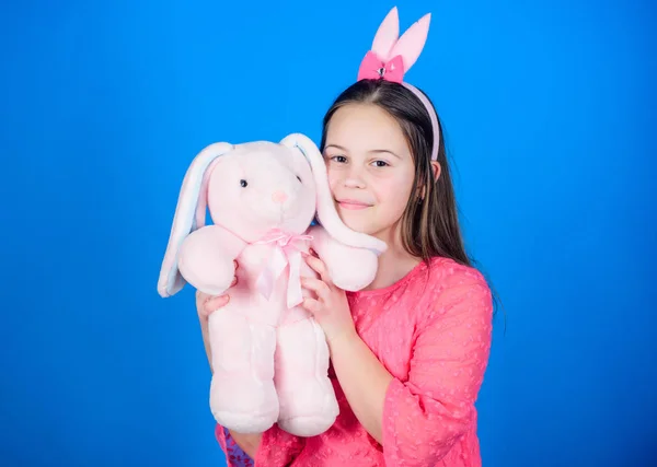 Bunny öron tillbehör. Härlig lekfull kanin barn kramar mjuk leksak. Kaninflicka med söt leksak på blå bakgrund. Barn leende spela bunny leksak. Har välsignat påsk. Få i påsk anda. Lycklig barndom — Stockfoto
