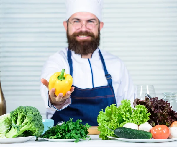 Koch kocht Paprika. Mann trägt Schürze Kochen in Küche. Mann Kochen gesundes Rezept Pfeffer Gemüse. Kochen als Hobby und Beruf. Bunt kulinarisch. vegetarisches Ernährungskonzept — Stockfoto