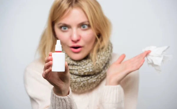 Nasal spray using. Cute woman nursing nasal cold or allergy. Unhealthy girl with runny nose using nasal spray. Treating common cold or allergic rhinitis. Sick woman spraying medication into nose