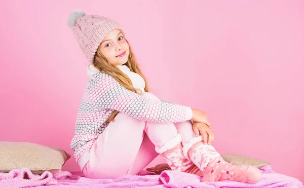 Menina cabelo longo relaxante fundo rosa. Moda de inverno de crianças. Criança modelo de moda sorridente. Kid girl use chapéu de malha bonito e roupas confortáveis e aconchegantes. Inverno conceito de moda — Fotografia de Stock