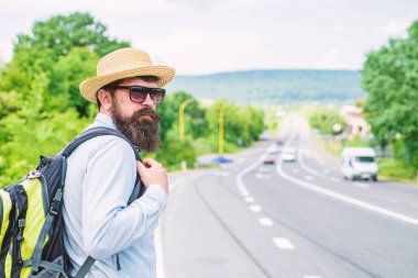 Man at edge of highway wait transport. Travel alone. Hitchhiking means transportation gained asking strangers for ride in their car. Hitchhiker travel alone try stop transport to get to destination clipart
