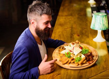 Zor iş günü sonra rahatla. İşadamı resmi elbise oturup bar sayacı. Adam yemek kızarmış patates kızarmış balık et ve lavaş ile aldı. O hak lezzetli bir yemek. Yemeğin keyfini çıkarın. Yüksek kalorili atıştırma