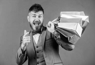 Karlı fırsatlar siyah Cuma alışveriş keyfini çıkarın. İndirimli alışveriş keyfini satın alma. Seçkin butik. Alışveriş daha neşeli hale getirin. Adam sakallı zarif işadamı gri arka plan üzerinde alışveriş torbaları taşımak