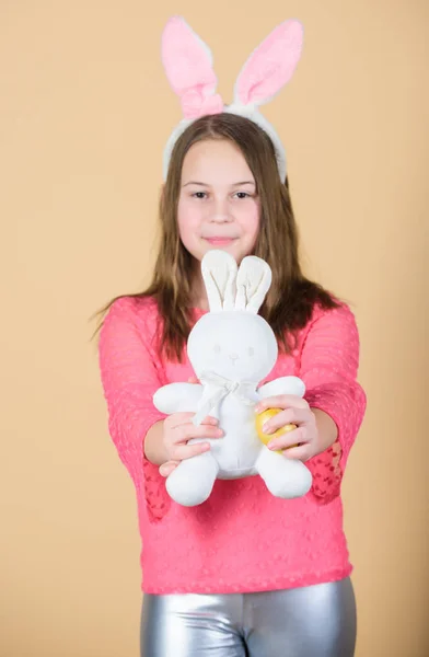Boldog gyermekkor. Húsvéti tevékenységek a gyermekek számára. Nyuszi ünnep kislány hosszú nyuszi füle. Gyermek aranyos nyuszi jelmez. Gyerek tartsa pályázati puha nyúl játék. Húsvéti nap jön. Ünnepeld a húsvétot — Stock Fotó