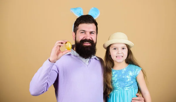 Enjoying the big day. Happy father and child with colored Easter eggs. Family of father bunny and daughter smiling on Easter. Happy family. Family celebrating Easter. Family at annual Easter egg hunt