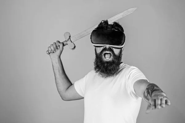 Hipster på skrika ansikte njuta spela spelet i virtual reality. VR gamer koncept. Mannen med skägg i Vr-Glasögon, ljusblå bakgrund. Killen med huvud monterad display och svärd spela fightingspel i Vr — Stockfoto