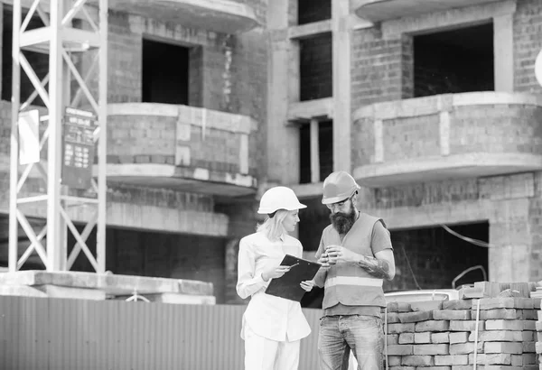 Relaties tussen bouw klanten en deelnemers bouwindustrie. Vrouw ingenieur en bouwer communiceren op de bouwplaats. Plan bespreken. Team communicatie bouwconcept — Stockfoto